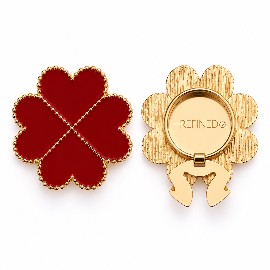 A four-leaf clover-shaped gold-tone decorative button cover with deep red heart-shaped sections and a gold-dotted outline, shown closed and open on a white background. Refined by JV branding is visible on the back beside the clip-on clasp mechanism