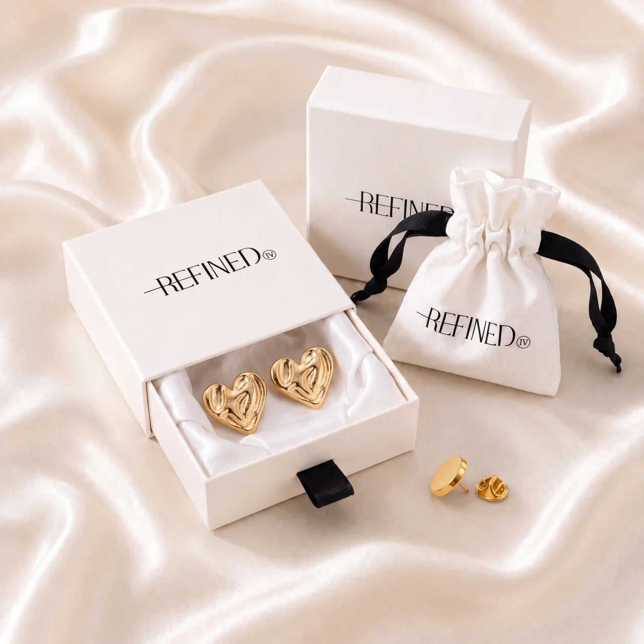 Refined by JV gold-tone heart button covers in a signature gift box with a drawstring travel pouch and pin.