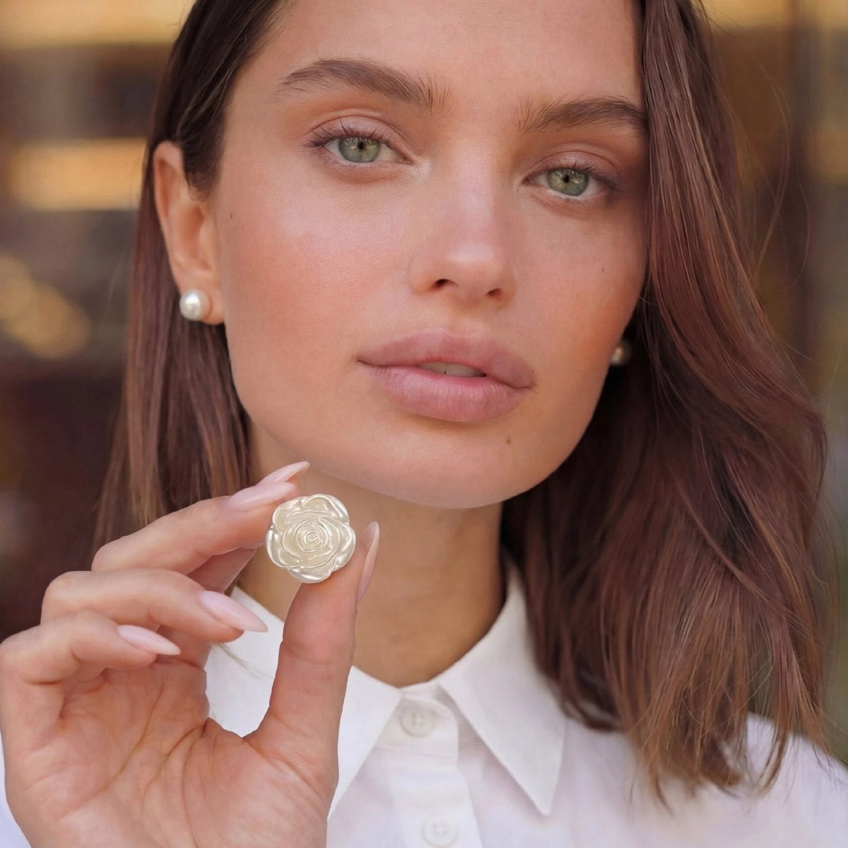 Refined by JV ivory pearlescent rose button cover held by a woman wearing a white shirt and pearl earrings