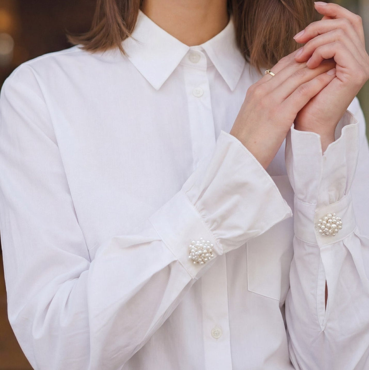 Refined by JV Ivory Sonata button covers featuring clusters of white pearls on gold-tone bases worn on shirt cuffs.