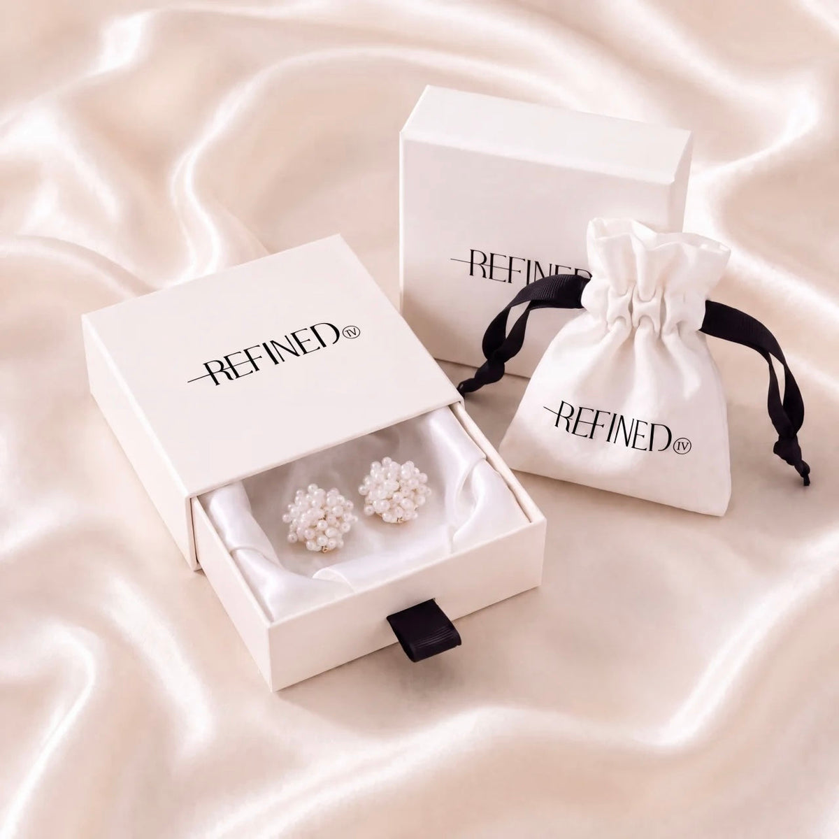 Refined by JV ivory pearl button covers in a signature gift box with a white drawstring travel pouch on satin fabric.