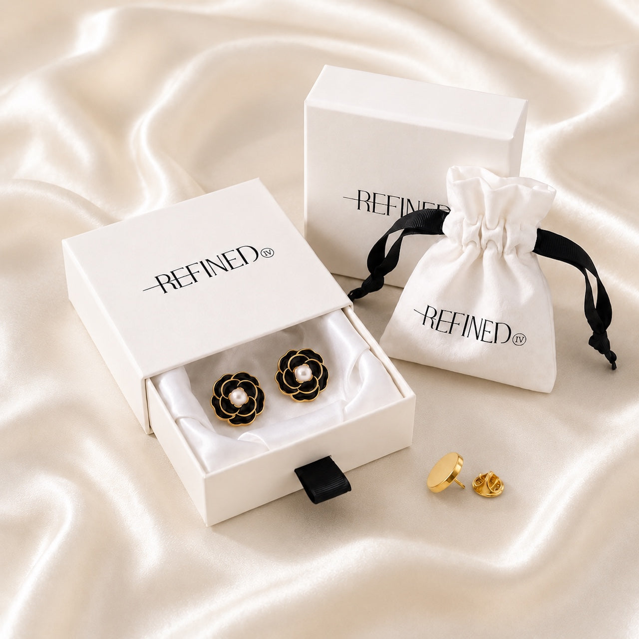 Refined by JV Noir Camélia button covers with black enamel, gold frame, and pearl center in a signature gift box.