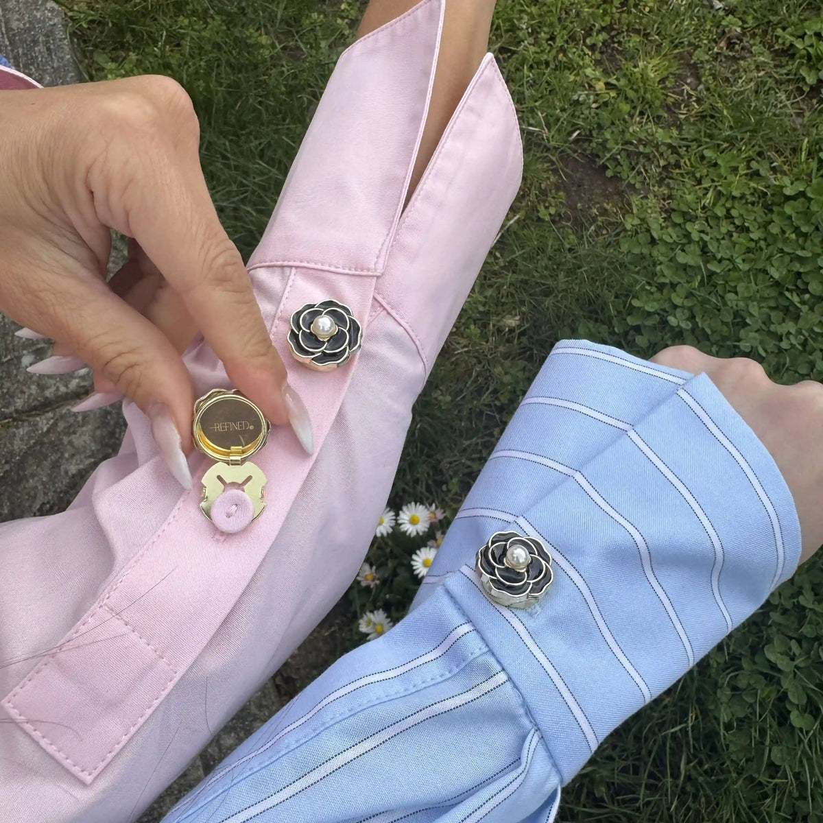 Refined by JV Noir Camélia button covers in black enamel with gold trim and pearl center attached to shirt cuffs.