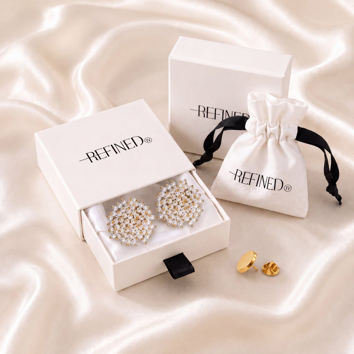 Refined by JV Pearl Cloud button covers in a gift box with a gold-tone pin and branded travel pouch on silk fabric.